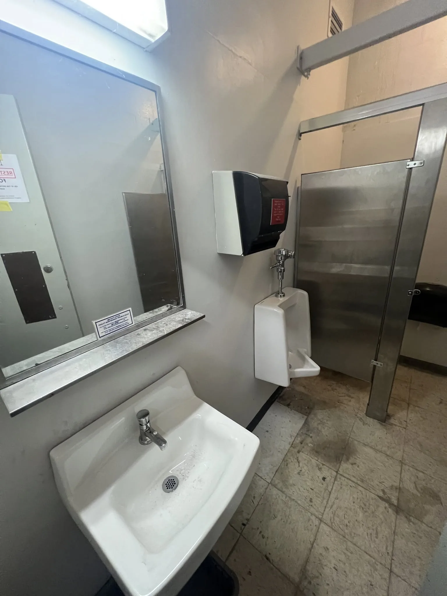 Commercial restroom showing stainless steel sinks and mirrors during construction.