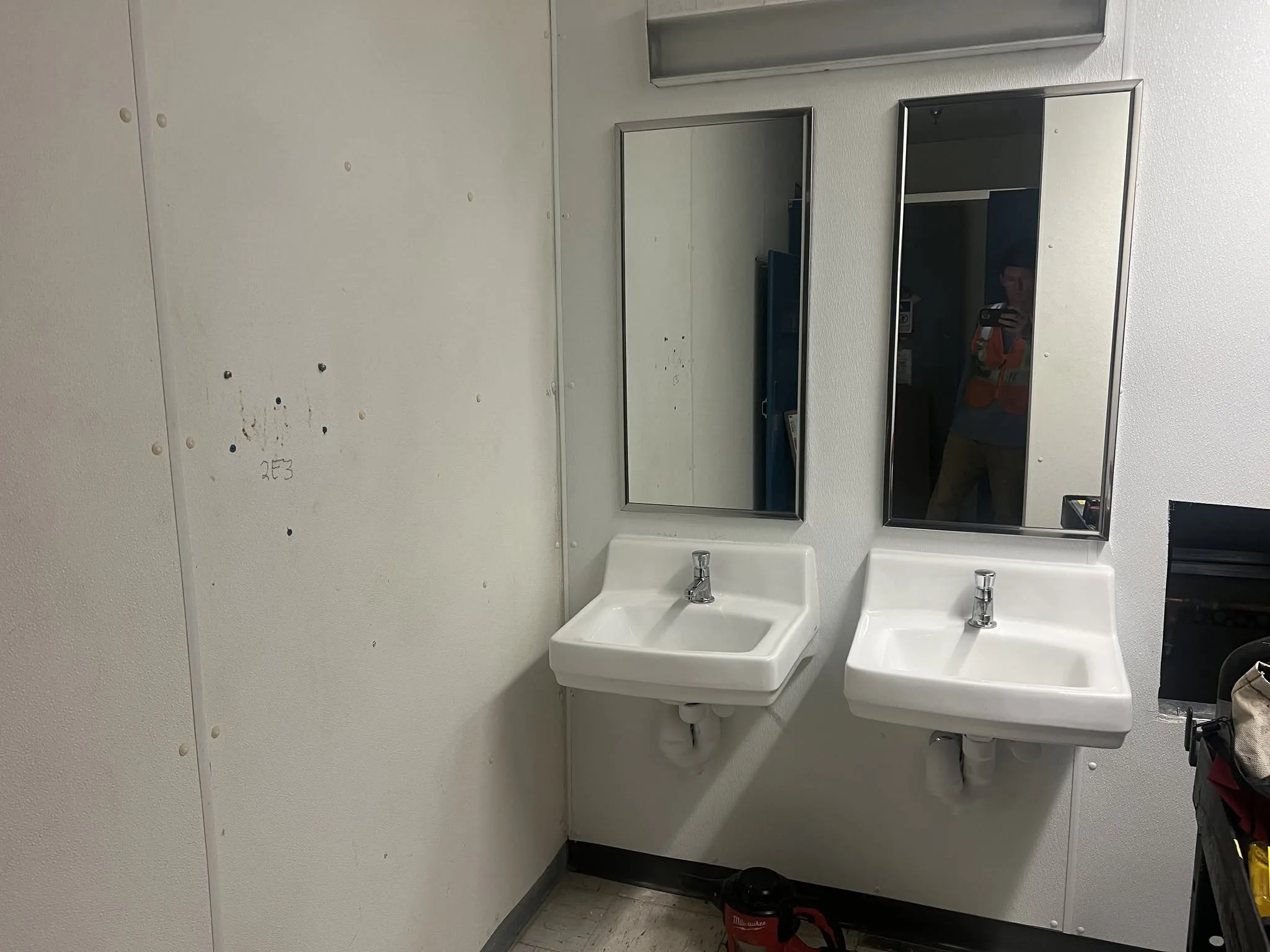 Finished commercial restroom with sinks, mirrors, and tile walls.