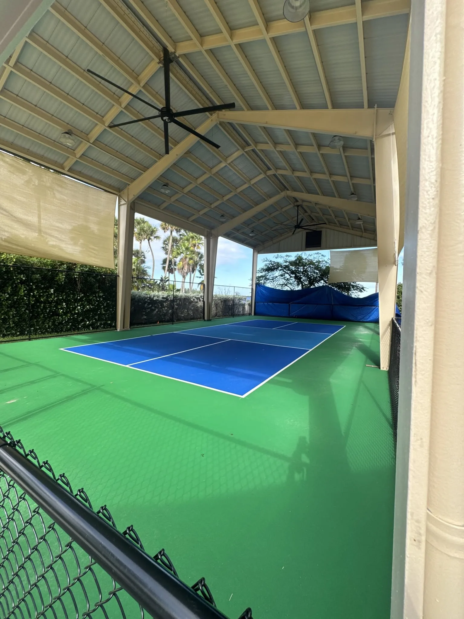 Open-air covered pavilion with green sports court flooring installed.