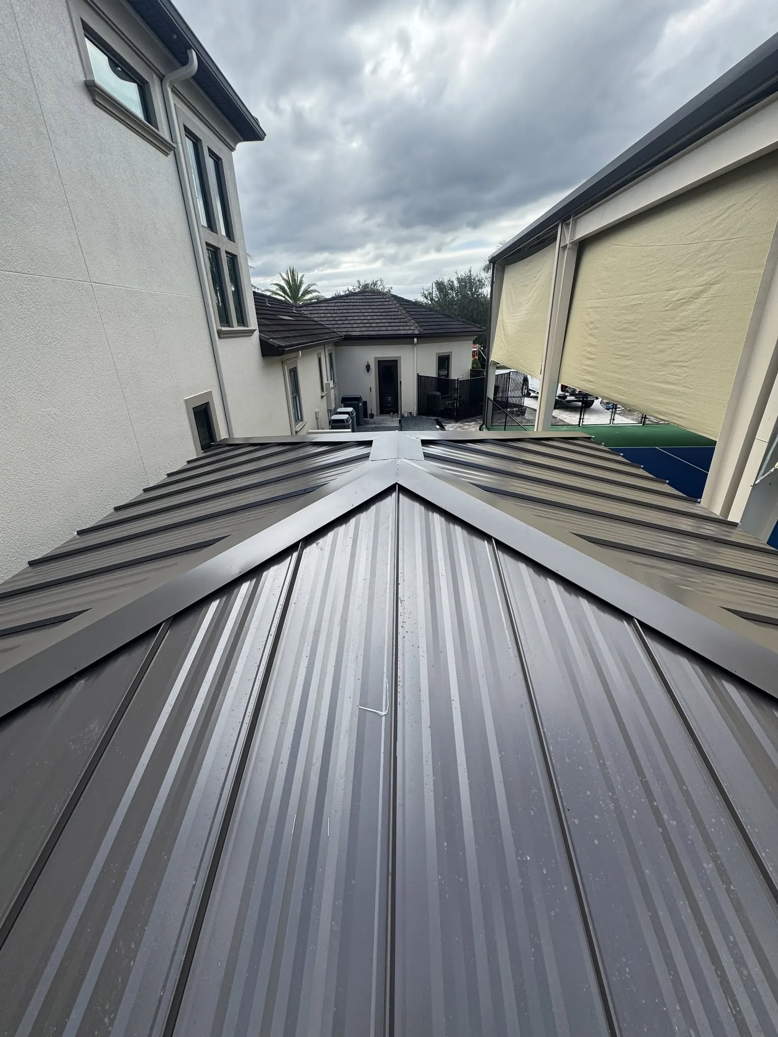 Completed standing seam metal roof installation on a residential building.