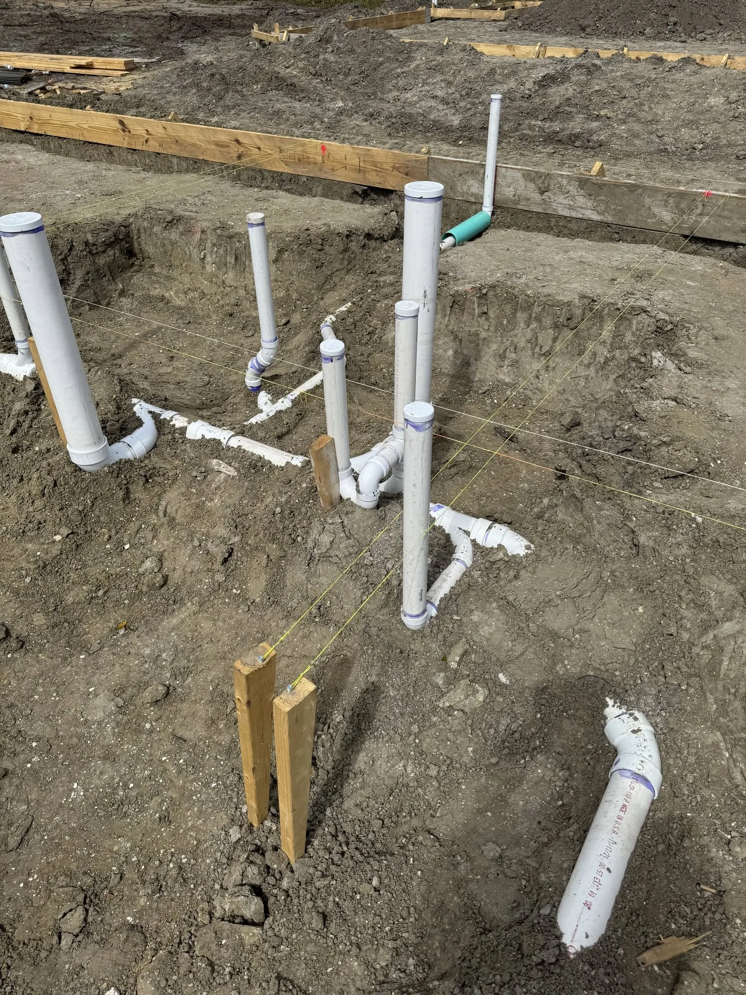 Underground PVC pipe rough-in during site construction.